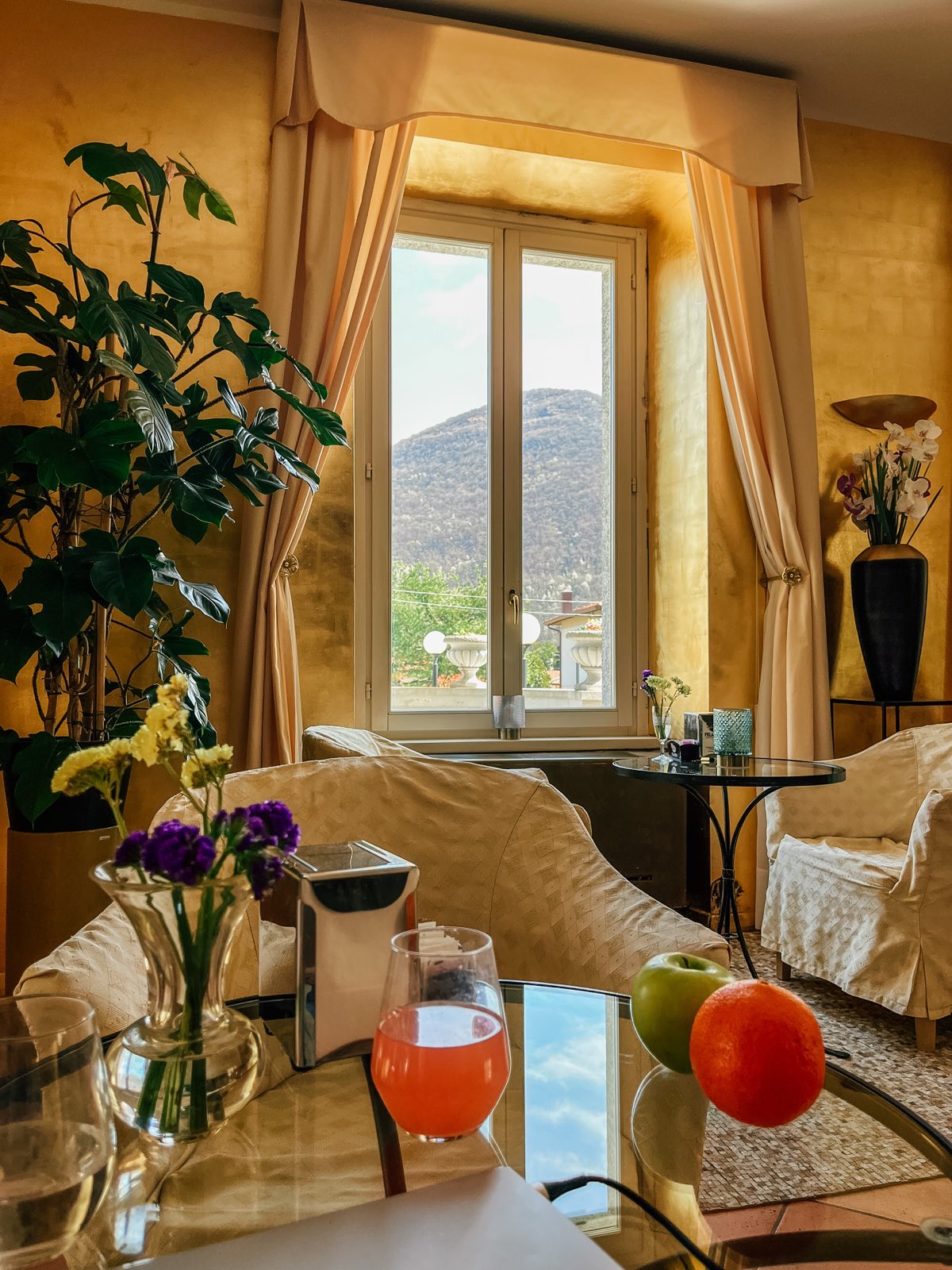 A gold-walled lounge with armchairs and the mountain in the window.