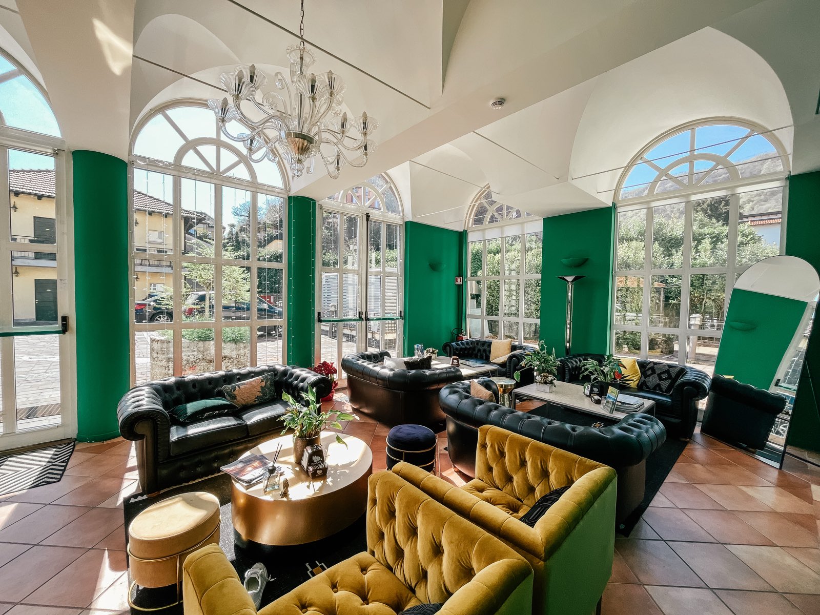 The winter garden: arched windows, green columns, chesterfield sofas and chandeliers.