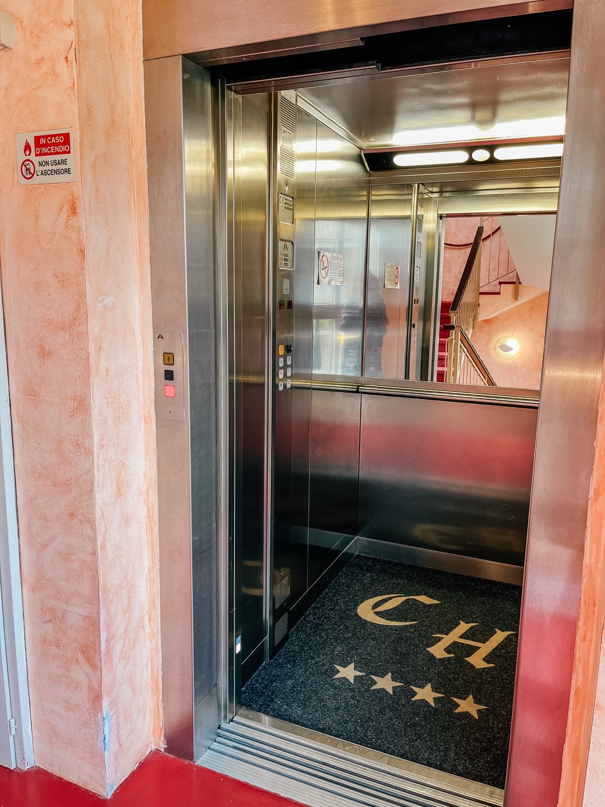 The lift, its floor mat woven with the CH monogram of Caroline Hotel and four stars.